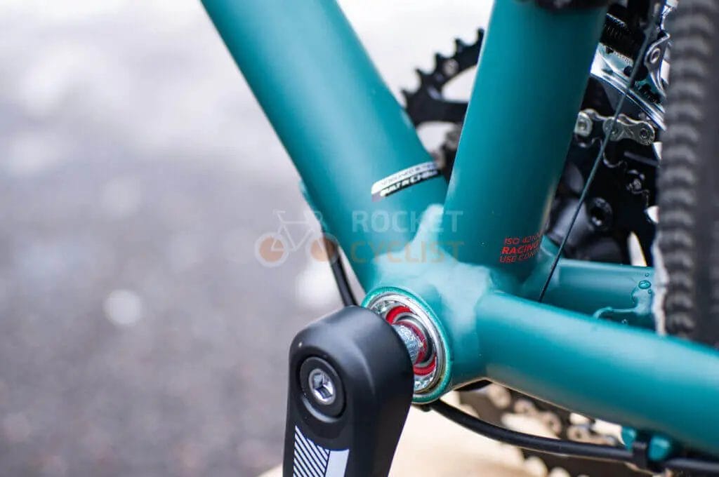 A close up of a green bicycle with a chain and gears.