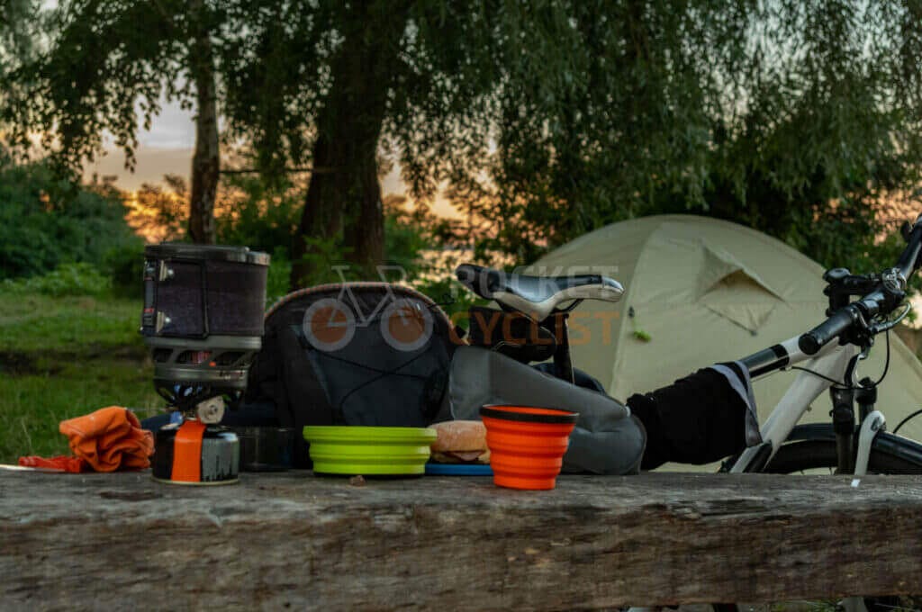 A bicycle sits on a wooden table next to a tent.