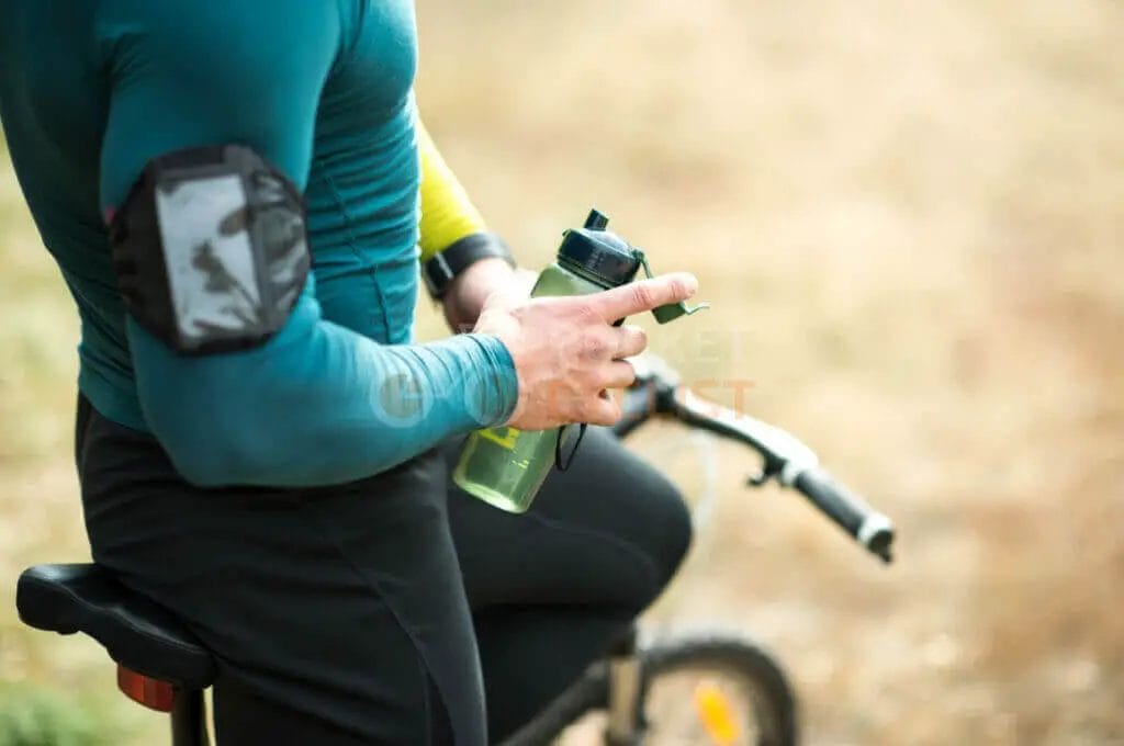 A man on a bike holding a water bottle.