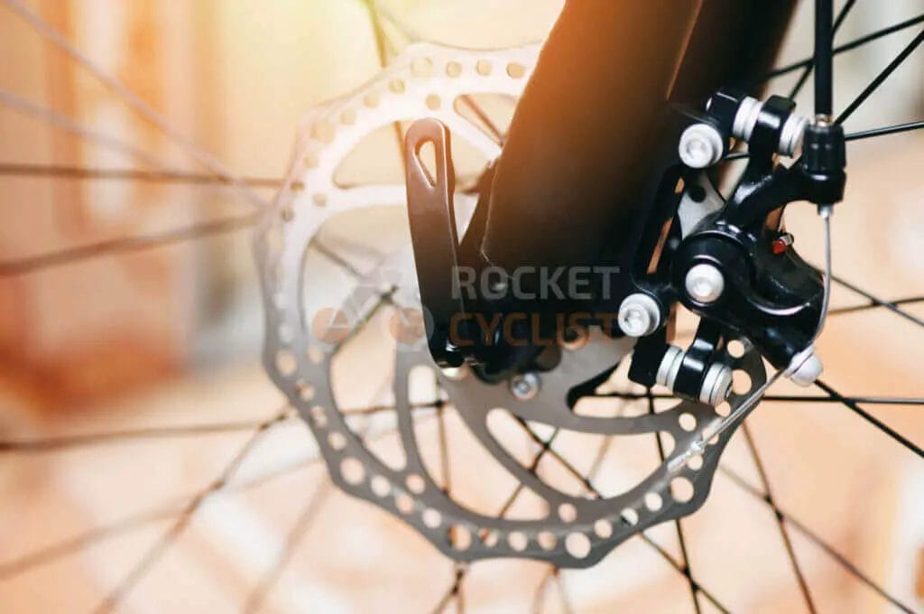 A close up of a bicycle's brake and disc.