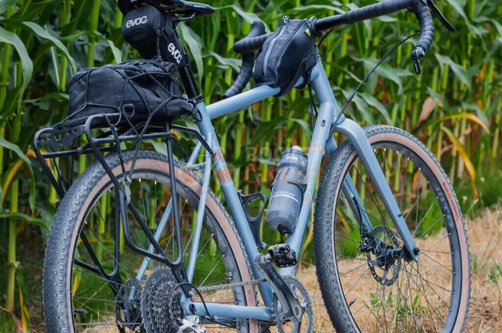 A bike is parked in front of a corn field.