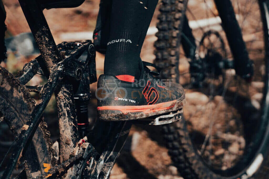 A person's feet on a mountain bike.
