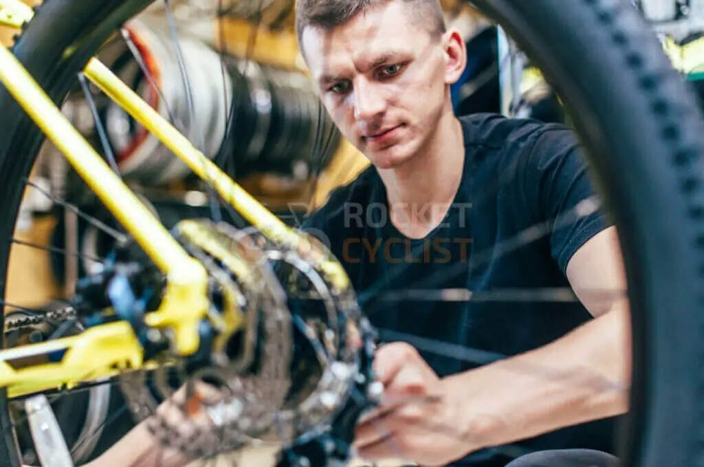 A man working on a bicycle in a shop.