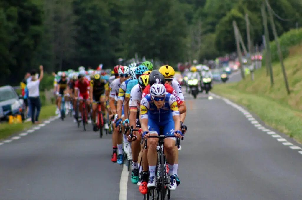 A group of cyclists riding down a road.