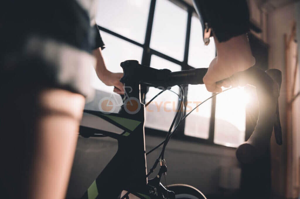 A person riding a bicycle in front of a window.