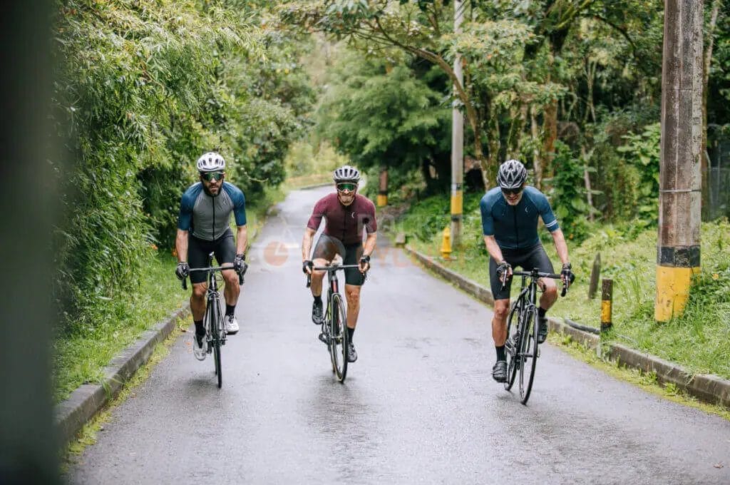 Three cyclists riding bikes down a road.