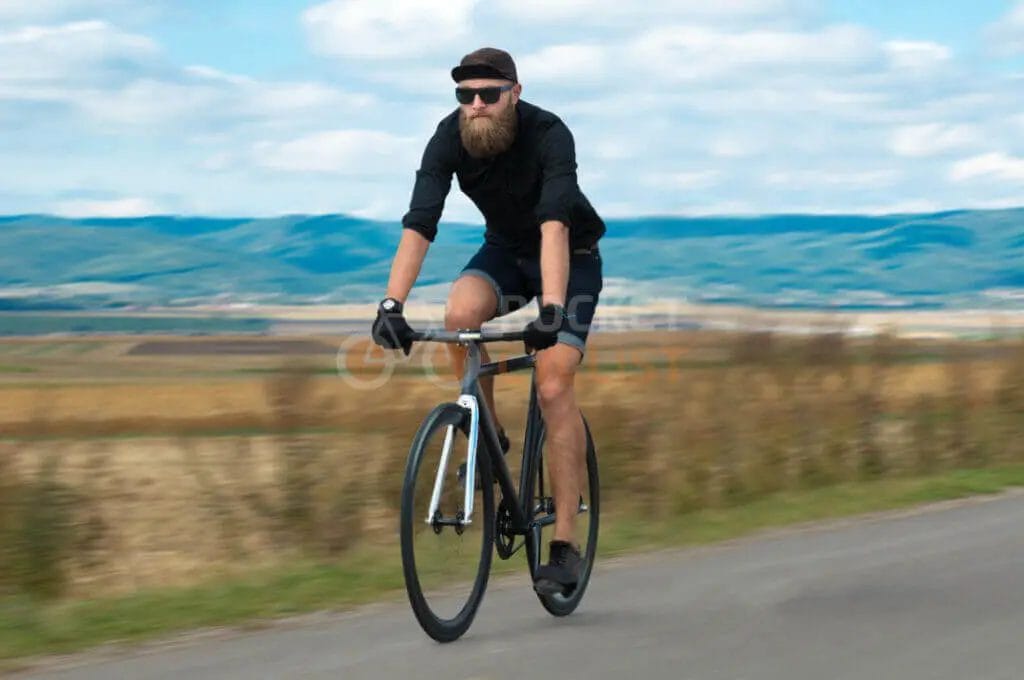 A man riding a bicycle on a country road.