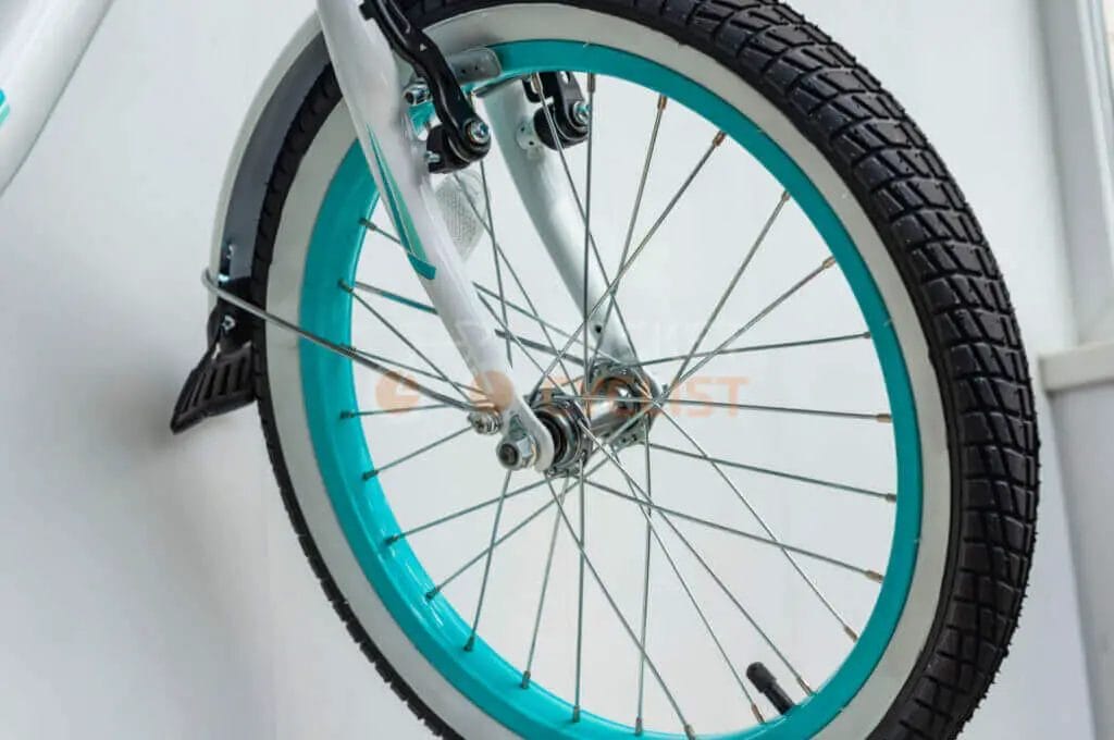 A bicycle with a blue wheel and white spokes.