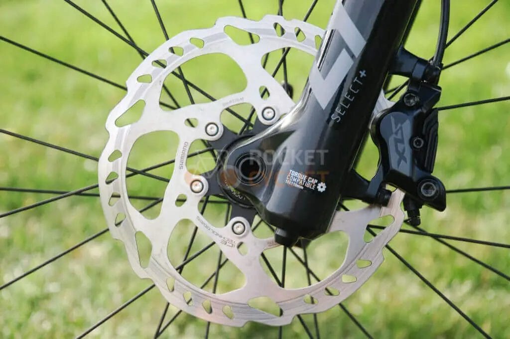 A close up of a bicycle disc and rotor.