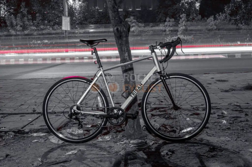 A bicycle leaning against a tree.