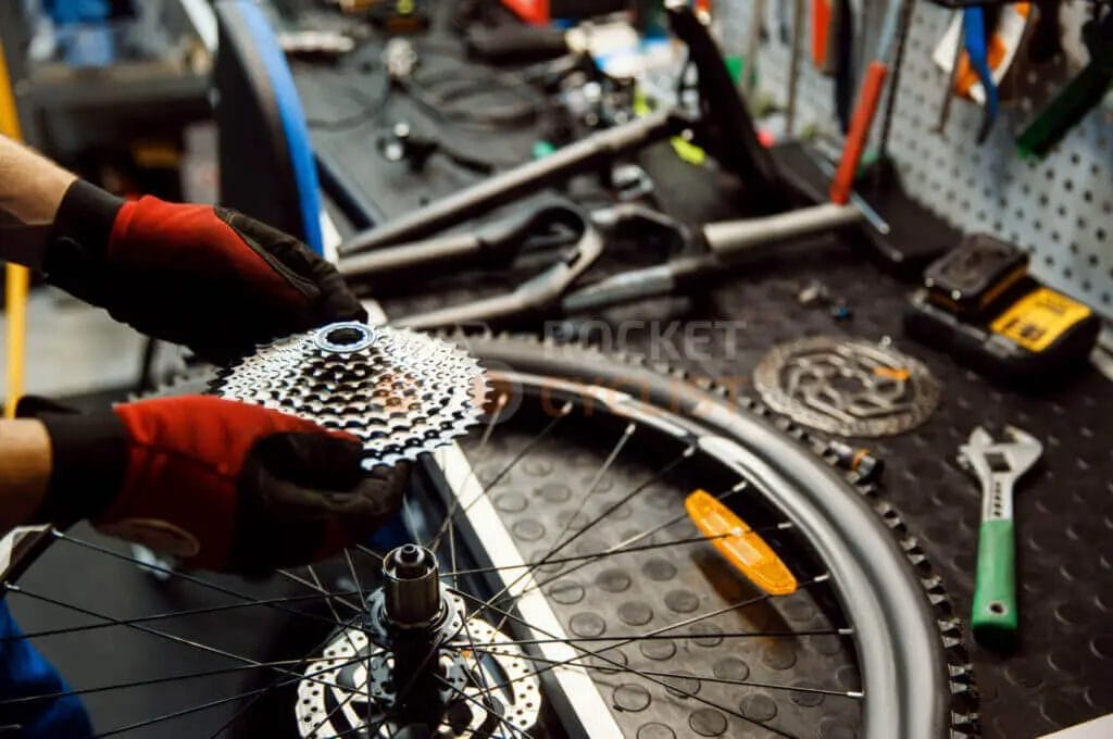 A person holding a bicycle gear.